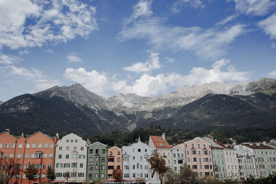 Buildings in town against cloudy sky