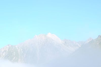 Scenic view of snow mountains against clear blue sky