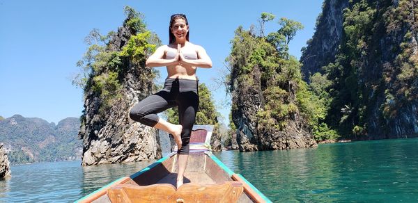 Yoga on a boat in surat thani, thailand.