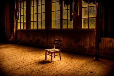 Empty chairs and table in abandoned building