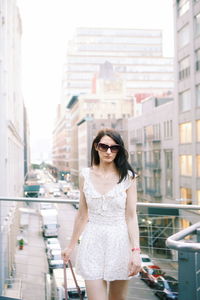 Young woman wearing sunglasses standing in city