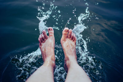 Low section of person feet in sea