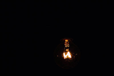 Close-up of illuminated light bulb in the dark