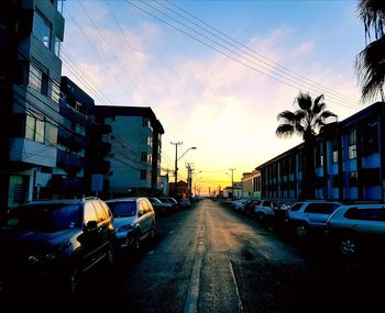 Cars on road amidst buildings in city against sky