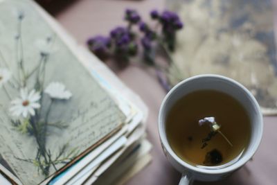 High angle view of herbal tea by stacked books on table