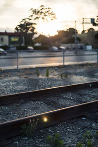 Close-up of railroad track against sky during sunset