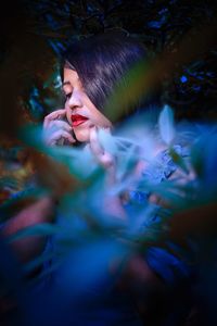 Woman with red lipstick amidst plants