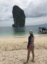 Woman standing on beach against sky