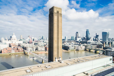 Buildings in city against cloudy sky