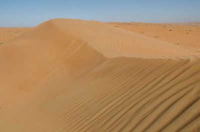 Sand dunes in desert against sky