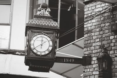 Low angle view of clock on wall in city