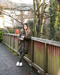 Portrait of young woman standing on footbridge