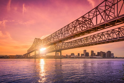 Bridge over river against sky during sunset