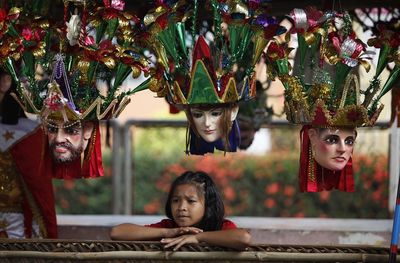 Cute girl looking away by hanging masks