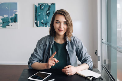 Portrait of young woman using mobile phone at home