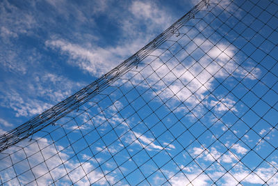 Low angle view of chainlink fence against sky