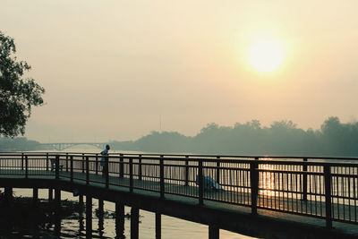 Bridge over pier against sky during sunset