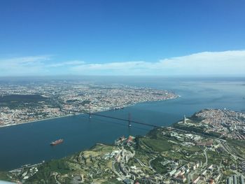 Aerial view of sea and buildings against blue sky