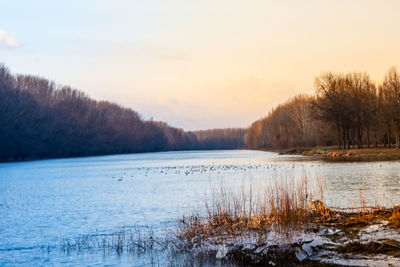 Scenic view of frozen lake against sky during sunset