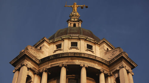 Low angle view of historic building against blue sky