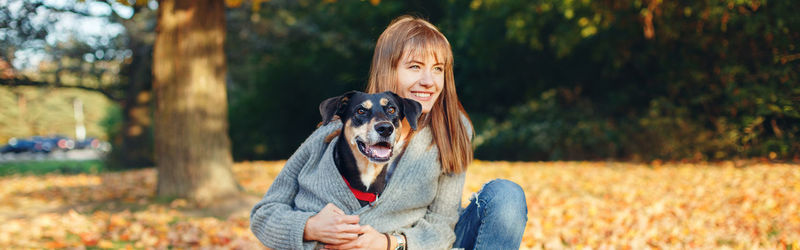 Portrait of woman with dog on field