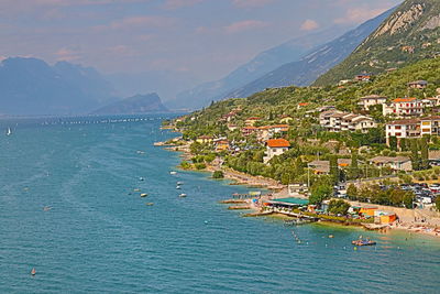 Aerial view of town by sea against sky