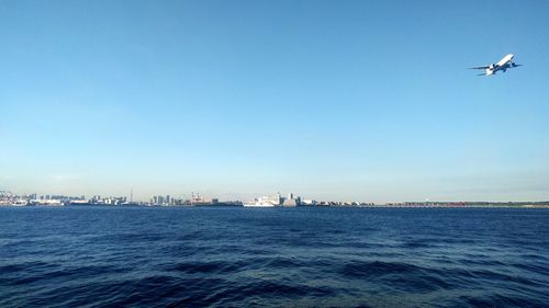 Boats in sea against clear sky