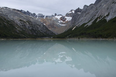 Scenic view of lake by mountains against sky