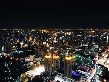 Illuminated cityscape against sky at night