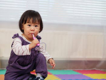 Close-up portrait of cute girl brushing teeth