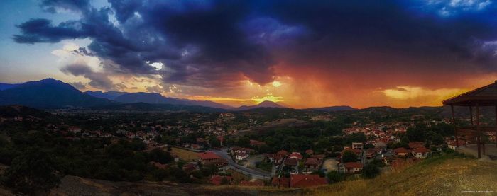 Town by mountains against sky during sunset