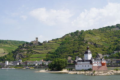 Buildings by sea against sky