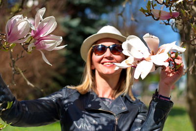 Portrait of young woman with magnolia blooming