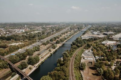 High angle view of river amidst city against sky