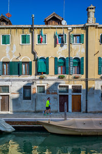 Man standing by building against clear sky