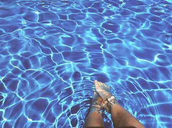 Low section of bare legs in water