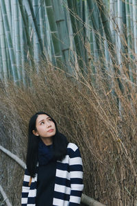 Woman standing against bamboos