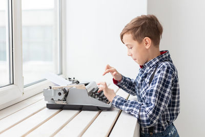 Side view of boy looking at camera at home