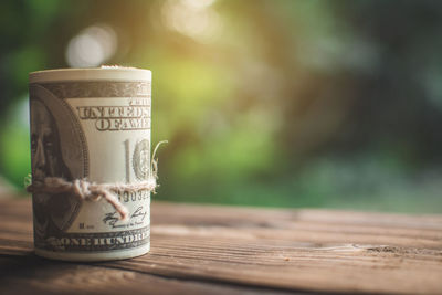 Close-up of rolled paper currency on wooden table