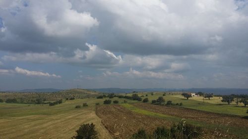 Scenic view of agricultural field against storm clouds