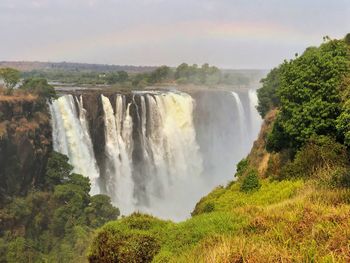 Scenic view of waterfall against sky