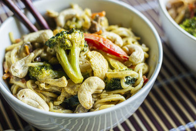 Close up of yellow curry stir-fried thai noodles bowl