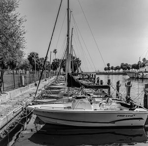 Boats moored at harbor against clear sky