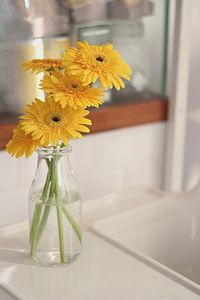 Close-up of yellow flower vase on table