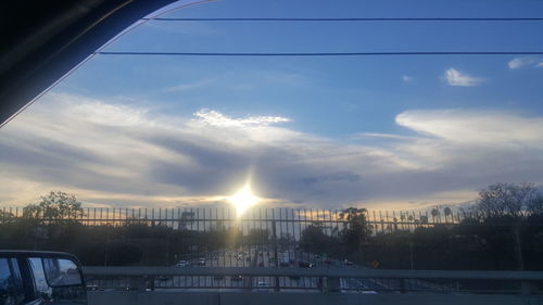 Cars on city against sky during sunset