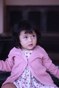 Portrait of cute girl sitting outdoors