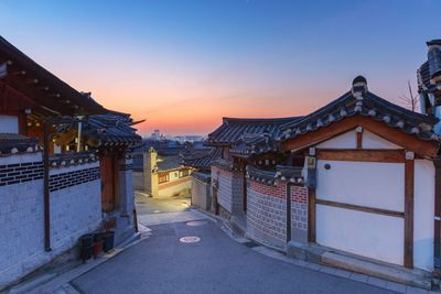 Street amidst buildings against clear sky at dusk