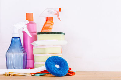 Close-up of various cleaning products on table against white background