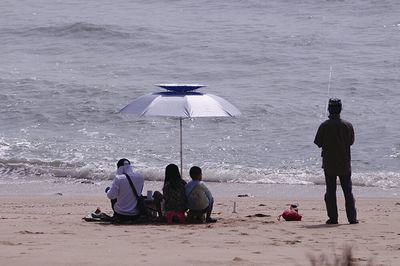 People on beach against sky