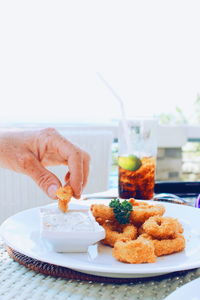 Close-up of hand holding ice cream in plate